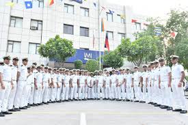Group of naval cadets marching in uniform outdoors, celebrating military discipline and training.