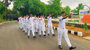 Line 2: Cadets practicing drill on road with formation and instructor leading.