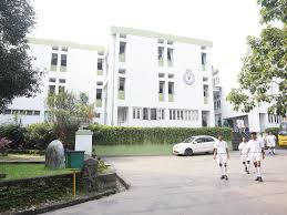 Modern white navy building with trees and parked cars, showcasing official maritime infrastructure.